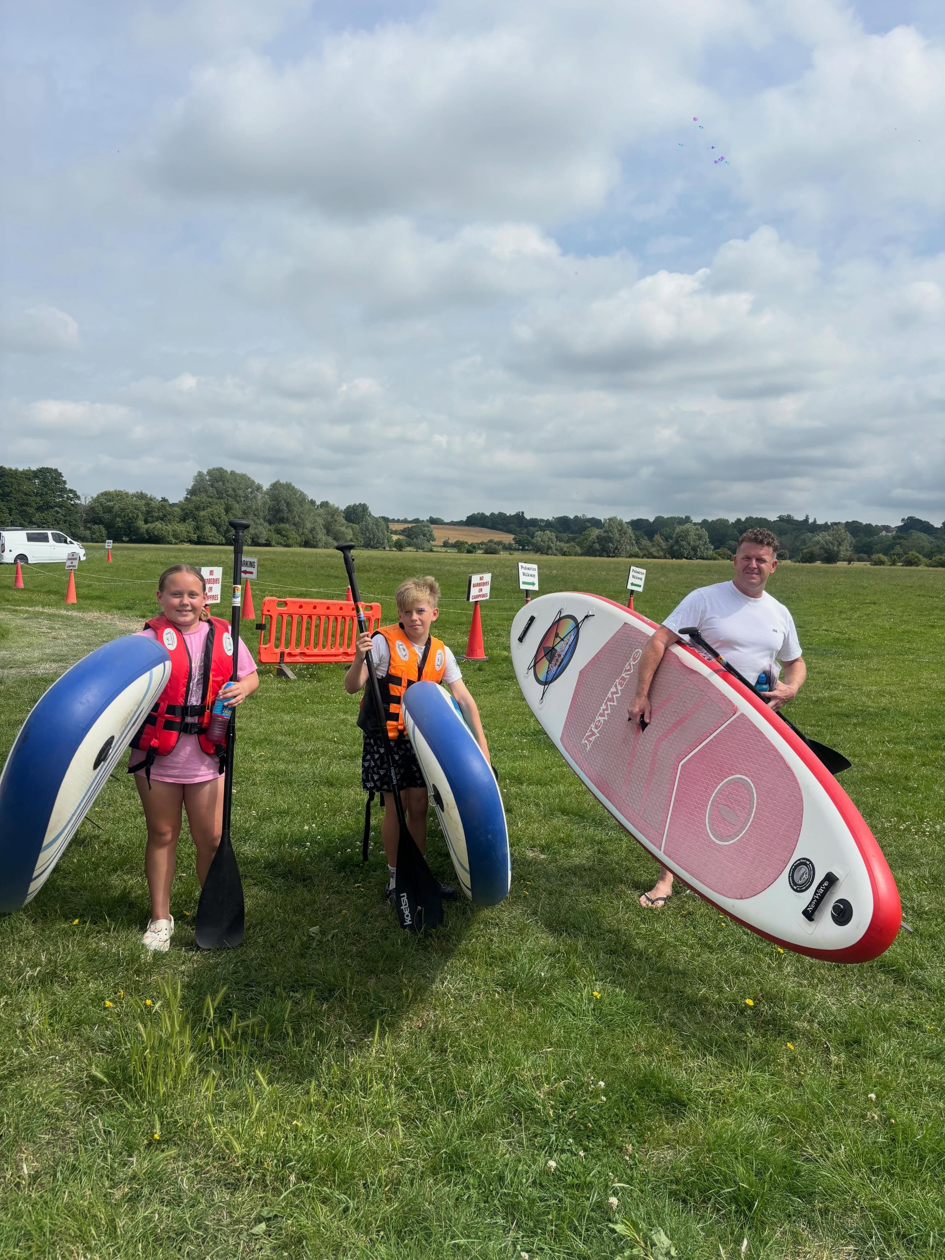 A family carrying their hire boards to the water